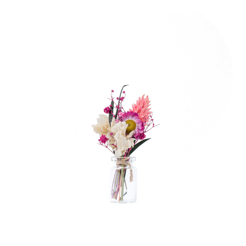 A pink dried flower mini bouquet in a mini vase