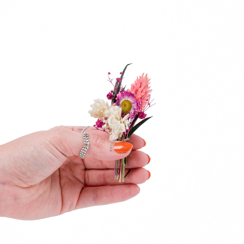 A pink dried flower mini bouquet in a hand