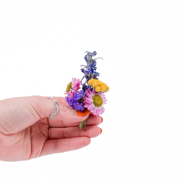 A colourful dried flower mini bouquet in a hand