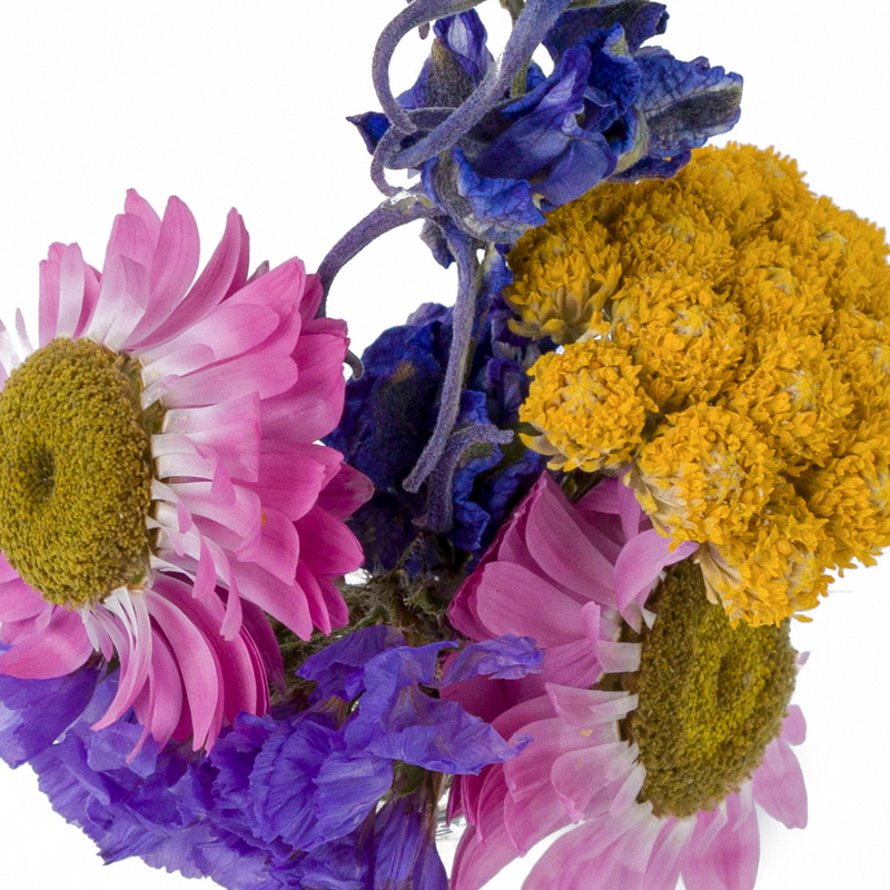 A close up of a colourful dried flower mini bouquet in a mini vase