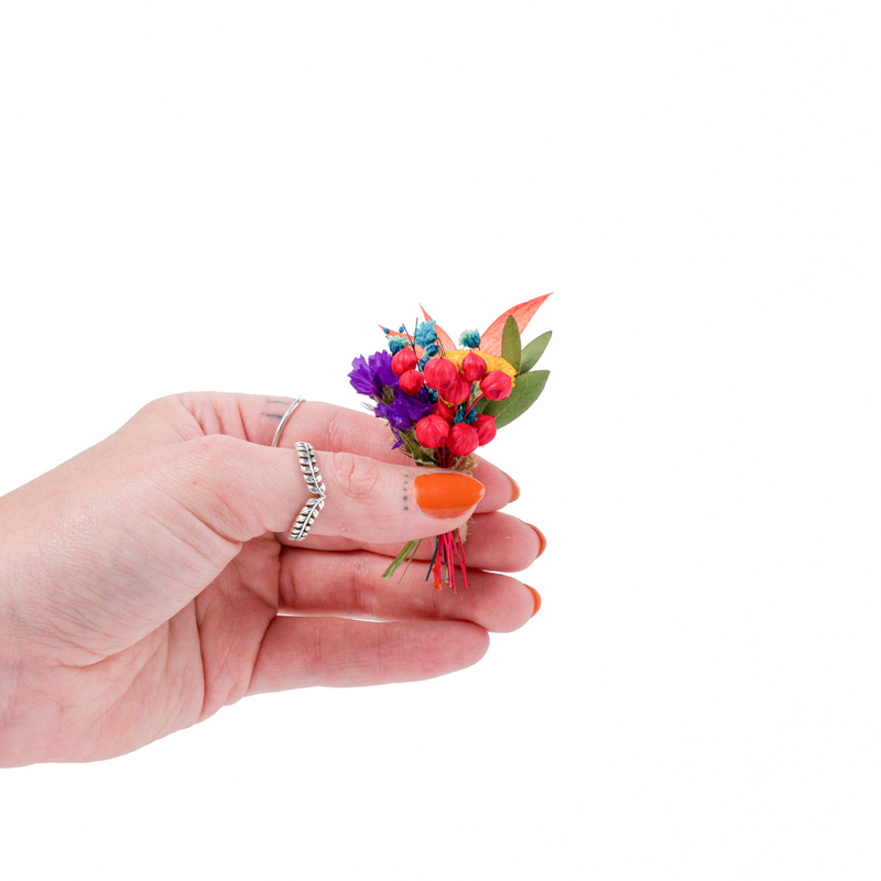 A rainbow dried flower mini bouquet in a hand