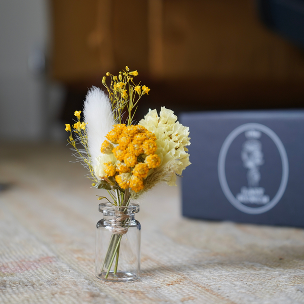 A yellow dried flower mini bouquet in a mini vase