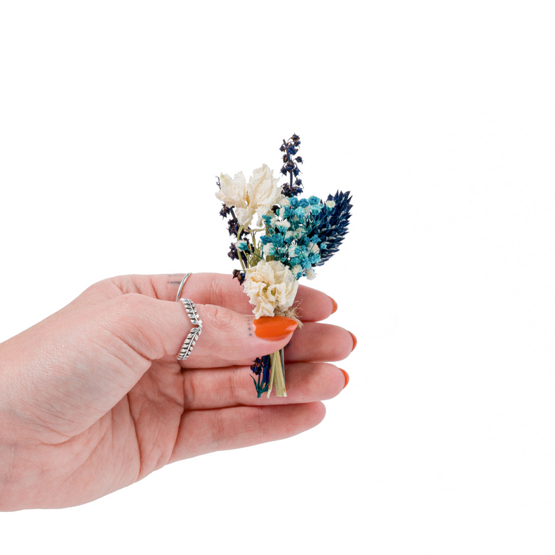 A blue dried flower mini bouquet in a hand