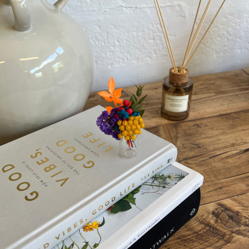 A rainbow dried flower mini bouquet in a mini vase