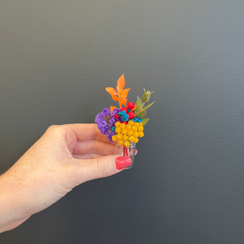 A rainbow dried flower mini bouquet in a mini vase