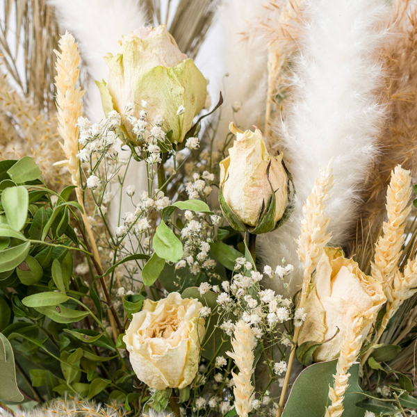 A close up of a green and cream dried flower bouquet