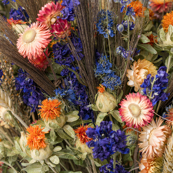 A close up of blue and orange dried flower bouquet
