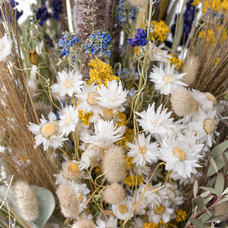 A close up of a blue and yellow dried flower bouquet