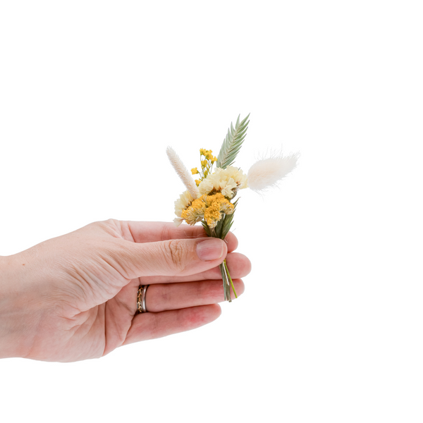 A yellow dried flower mini bouquet in a hand