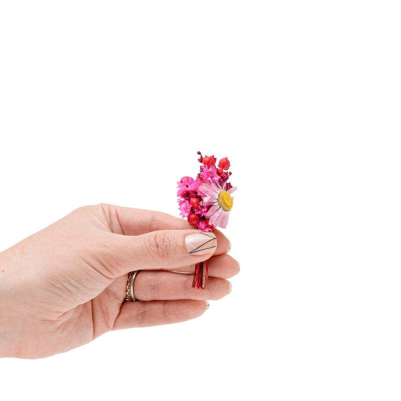 Pink and red dried flower mini bouquet being held in a hand