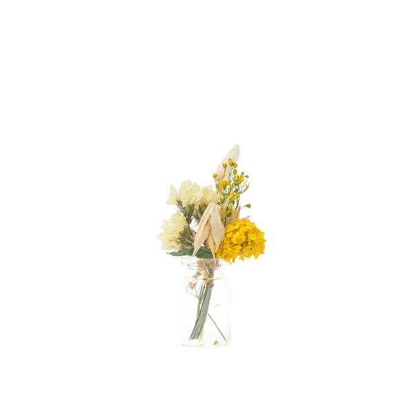 A yellow mini bouquet made from dried flowers that are not toxic for pets in a mini vase