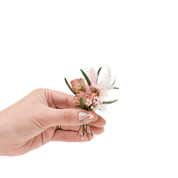 Pink and cream dried flower mini bouquet with roses in a hand