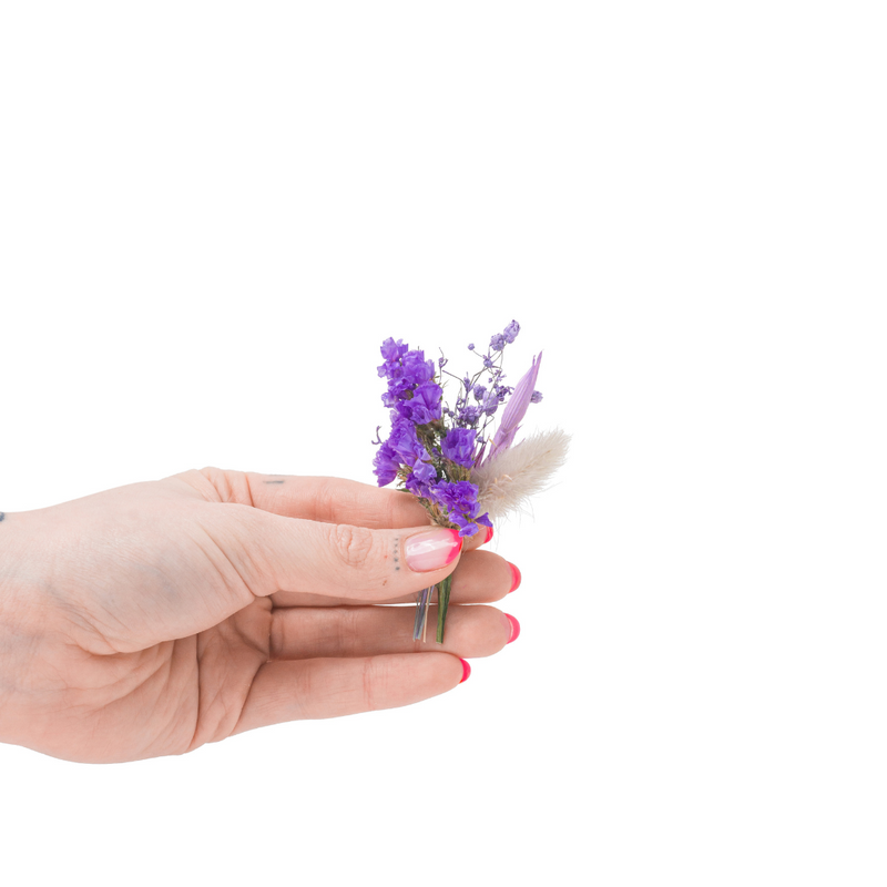A purple mini bouquet made from dried flowers that are not toxic for pets in a hand