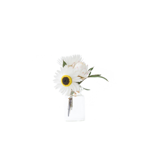 A white dried flower mini bouquet in a mini vase