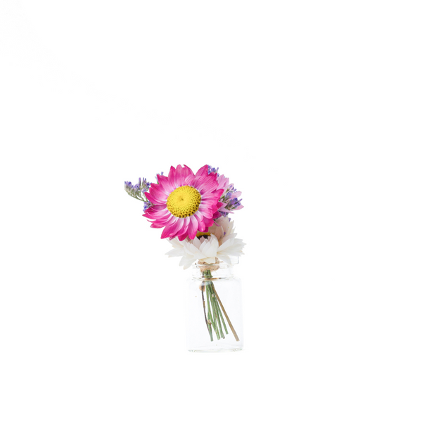 A pink and white dried flower mini bouquet in a mini vase