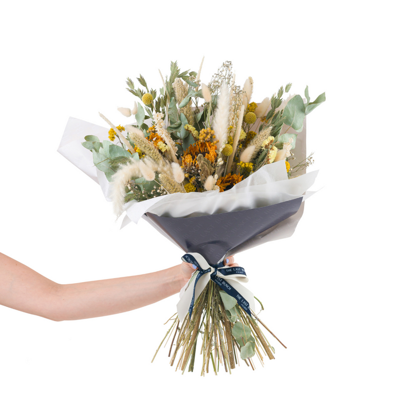 A yellow dried flower bouquet with dried sunflowers
