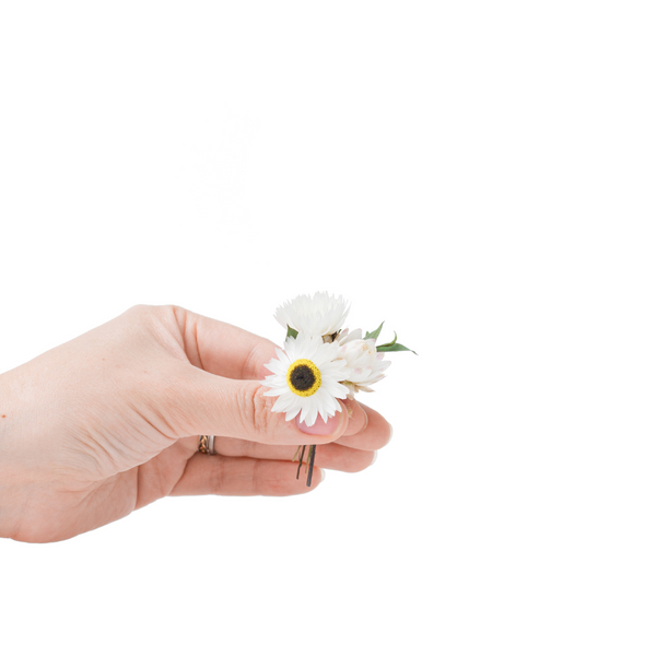 A white dried flower mini bouquet in a hand