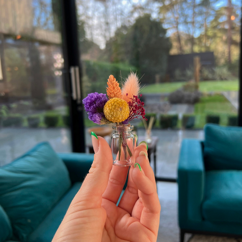 A bright colourful dried flower mini bouquet in a mini vase