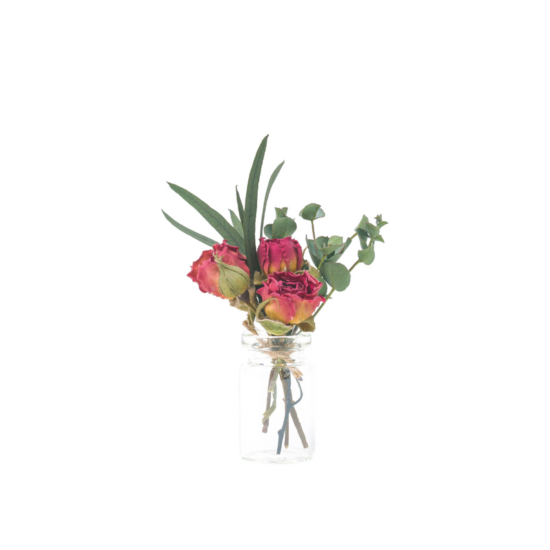 A mini bouquet made from dried red roses in a mini vase
