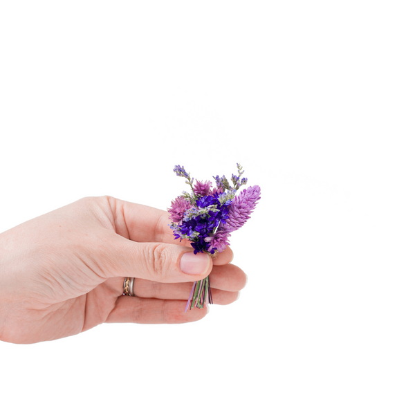 A purple dried flower mini bouquet in a hand