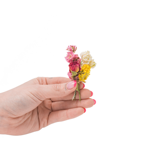 A bright and colourful mini bouquet in a hand