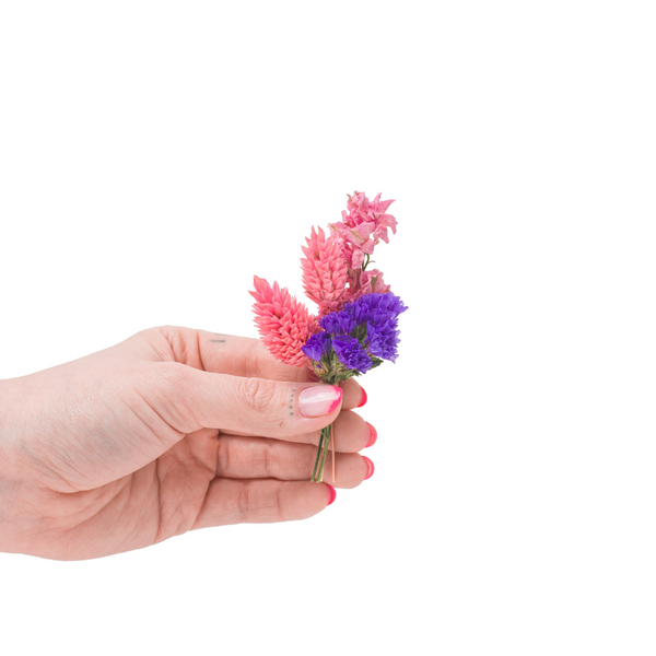 Pink and purple dried flower mini bouquet in a hand