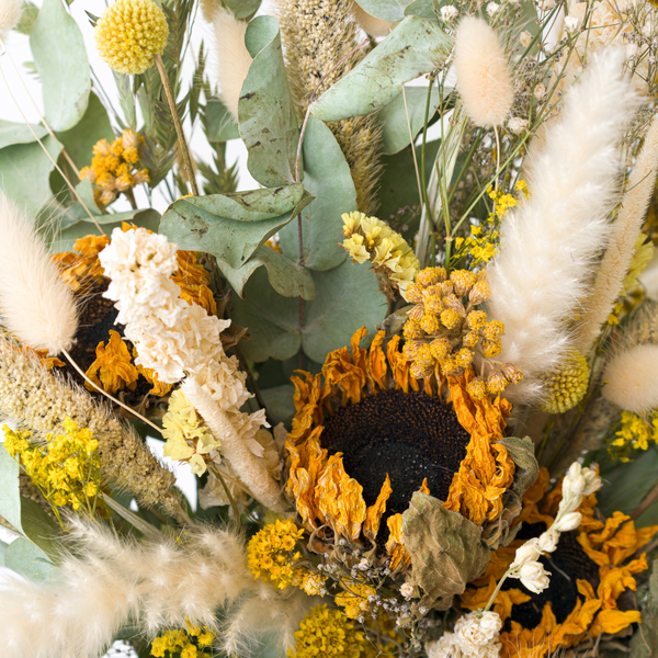 A close up of a yellow dried flower bouquet with dried sunflowers