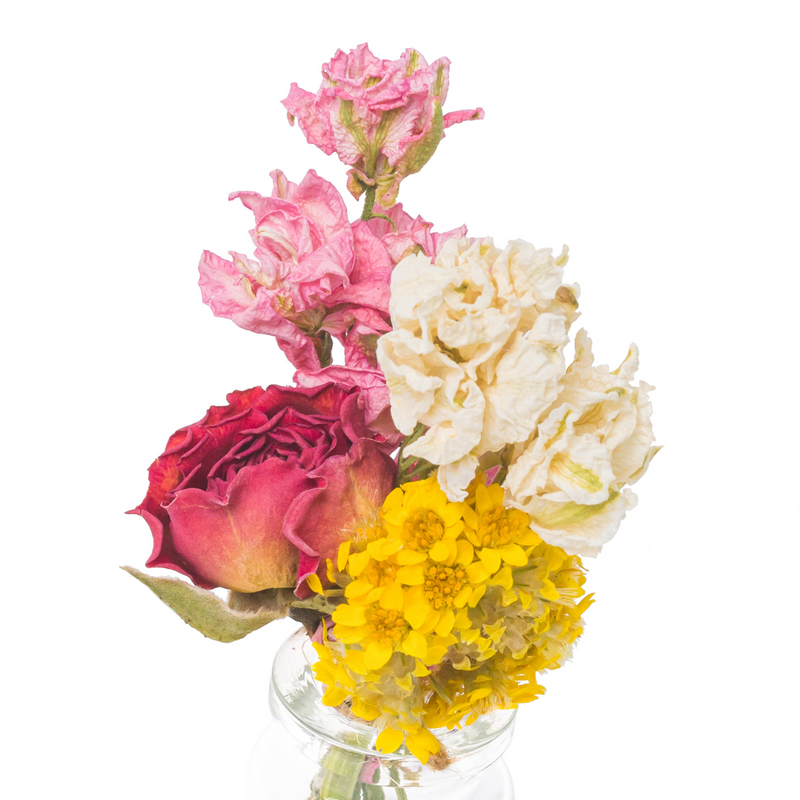 A close up of a bright and colourful mini bouquet in a mini vase