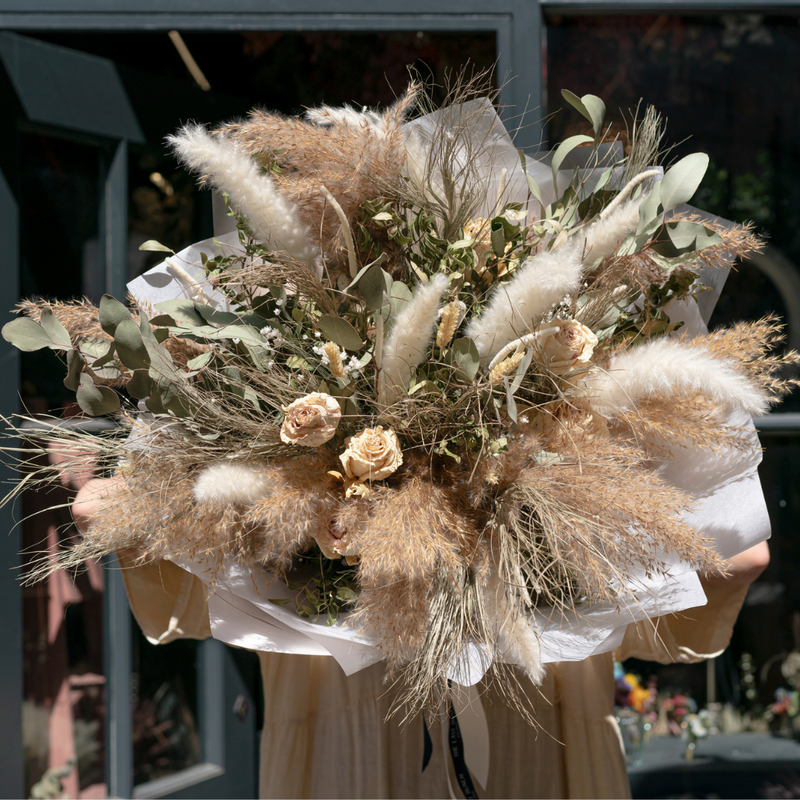 A giant green and cream dried flower bouquet