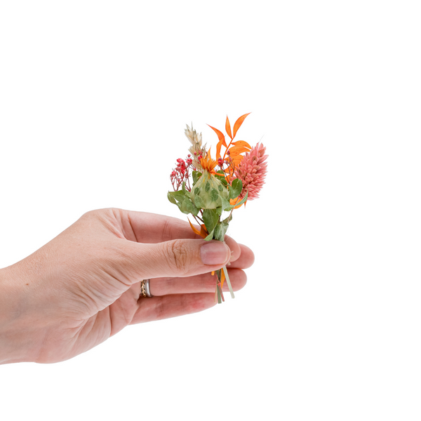 A orange dried flower mini bouquet in a hand