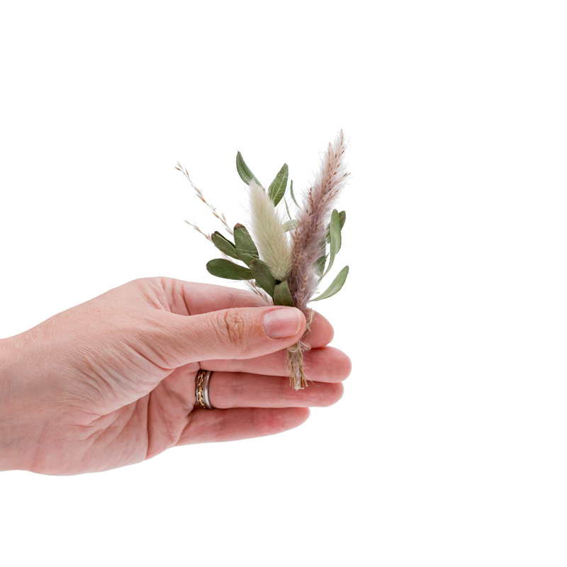 A foliage dried flower mini bouquet in a hand